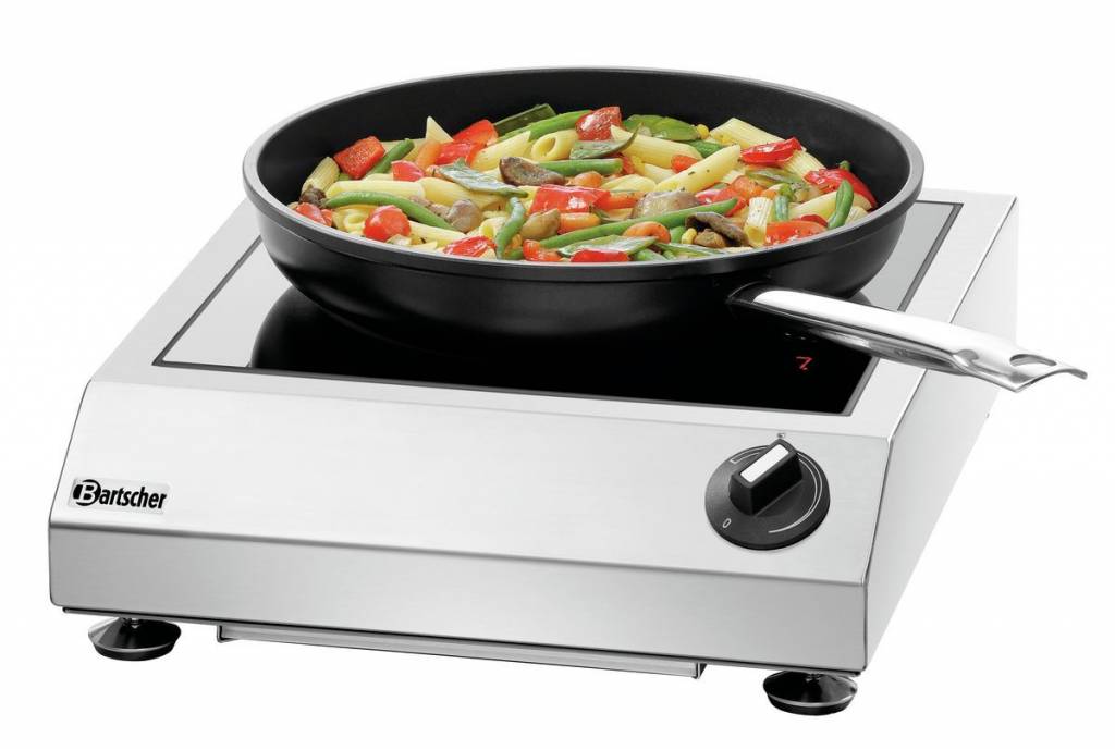 Mobiles Induktionskochfeld aus Edelstahl mit Pfanne und gebratenem Gemüse mit Nudeln.