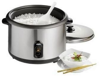 Geöffneter Reiskocher aus Edelstahl mit gekochtem Reis, Reislöffel und Schale